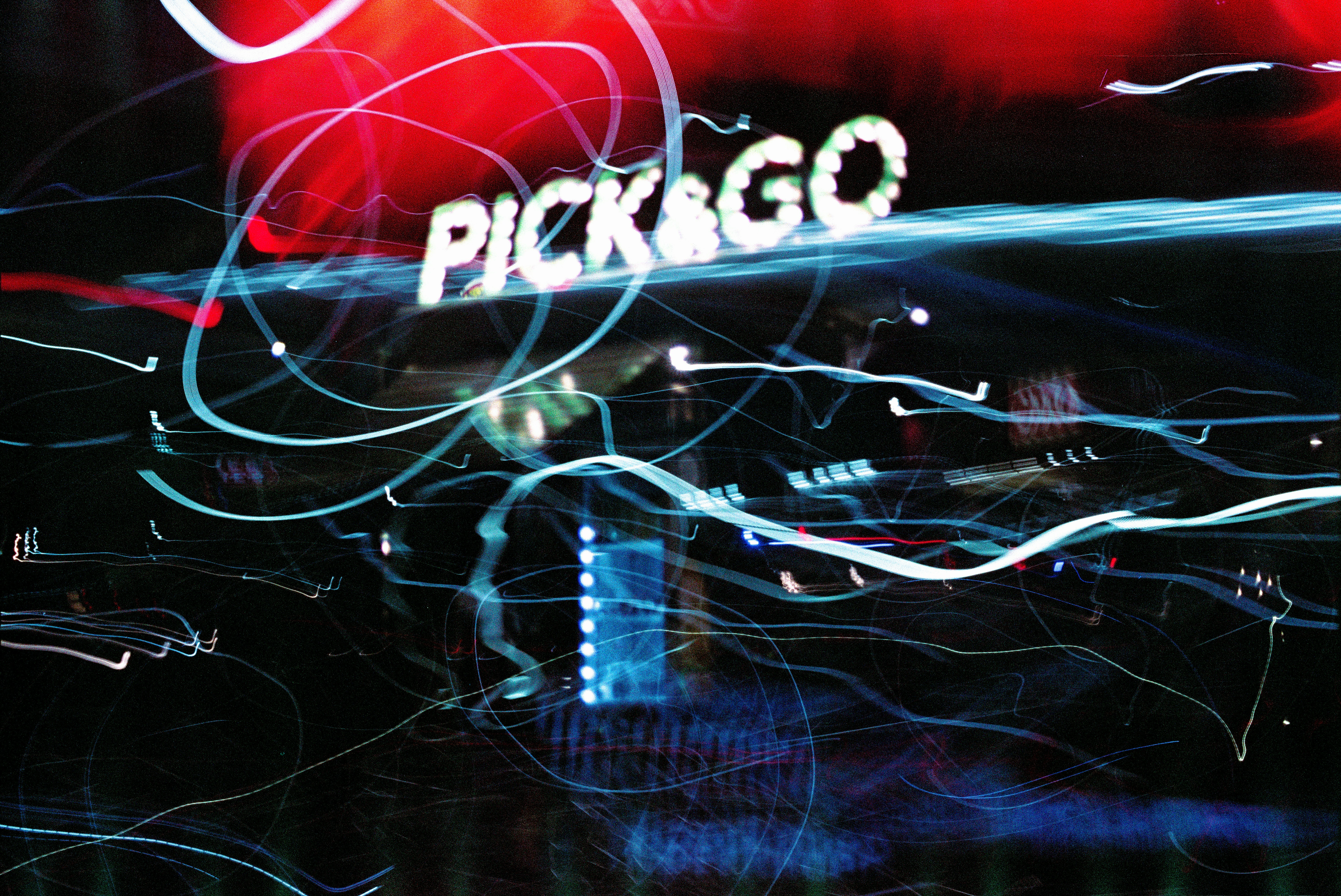 a blurry photo of a neon sign that says pick \u0026 go